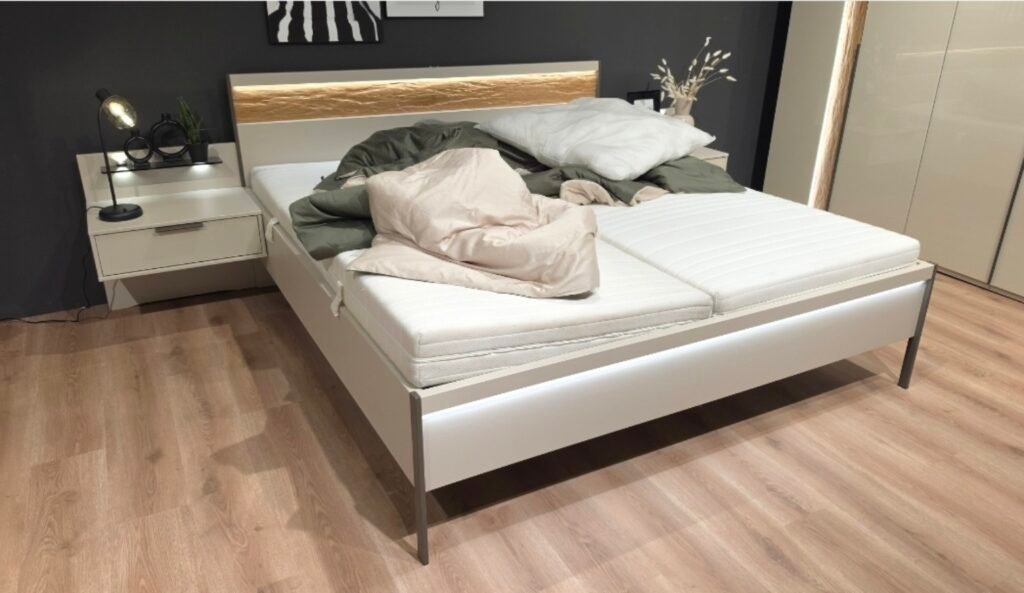 Helles Bett mit Holzakzent und beleuchtetem Kopfteil in der NIKO Ausstellung